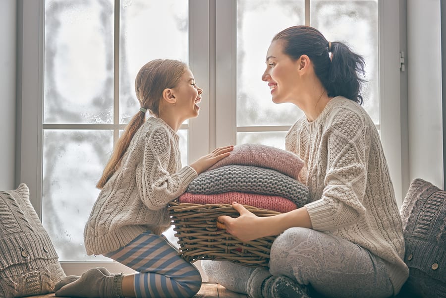 Mother and Happy girl having fun wearing knitted sweaters
